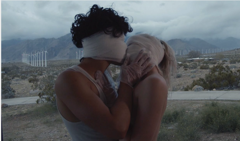 Still elokuvasta Seek Bromance. Päähenkilöt suutelevat silmät sideharsolla peitettynä keskellä aavikkoa.
